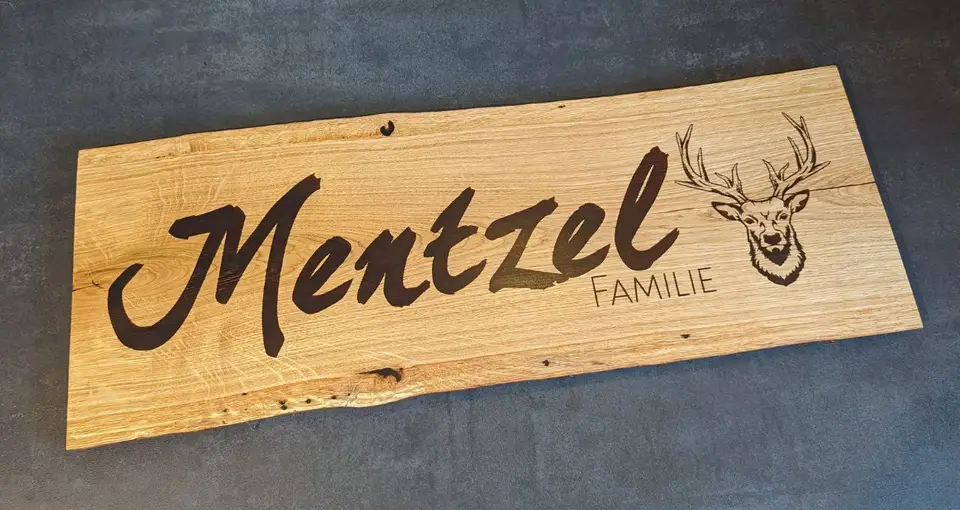 Ein graviertes Eichenschild mit der Aufschrift Mentzel Familie und einem Hirschmotiv